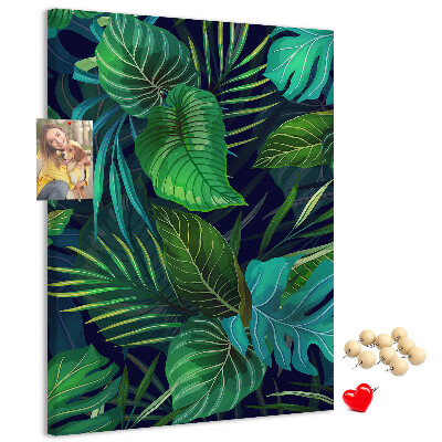 Memobord van kurk met tropische bladeren op een donkere achtergrond