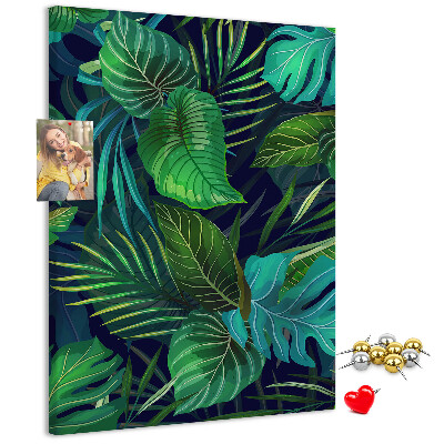 Memobord van kurk met tropische bladeren op een donkere achtergrond