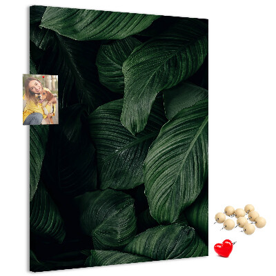 Kurken prikbord met print van groene bladeren op een donkere achtergrond