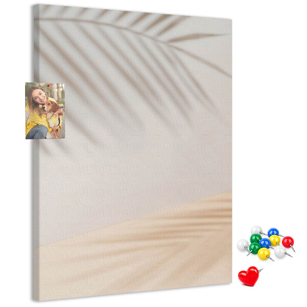 Prikbord van kurk met subtiele schaduwen van palmbomen op een lichte achtergrond