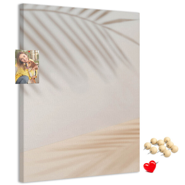 Prikbord van kurk met subtiele schaduwen van palmbomen op een lichte achtergrond