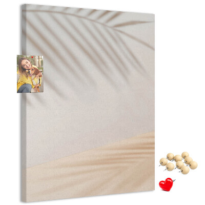 Prikbord van kurk met subtiele schaduwen van palmbomen op een lichte achtergrond