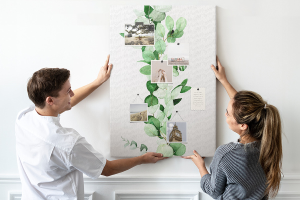 Kurken memobord met groene bladeren op een lichte achtergrond