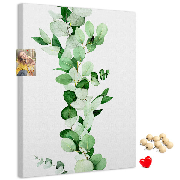 Kurken memobord met groene bladeren op een lichte achtergrond