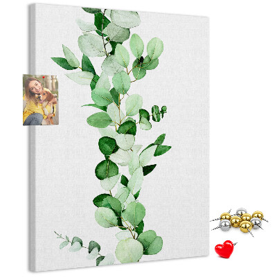 Kurken memobord met groene bladeren op een lichte achtergrond