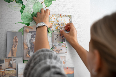 Kurken memobord met groene bladeren op een lichte achtergrond
