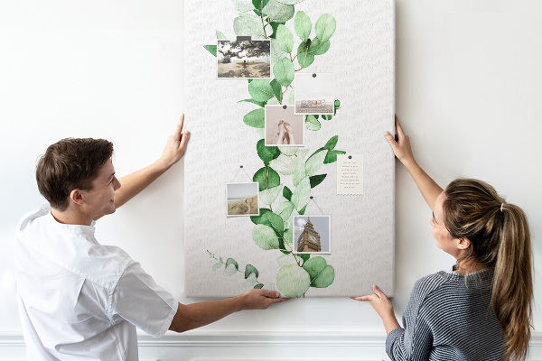 Kurken memobord met groene bladeren op een lichte achtergrond
