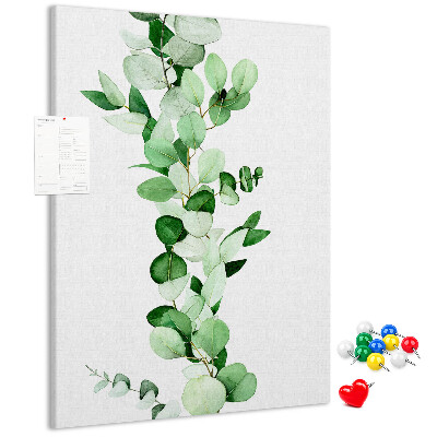 Kurken memobord met groene bladeren op een lichte achtergrond
