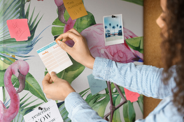 Prikbord van kurk met vrolijke flamingo's in een tropische omgeving