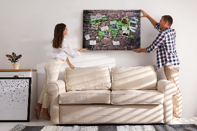 Prikbord met een wereldkaart in groentinten op een stenen muur