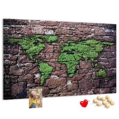 Prikbord met een wereldkaart in groentinten op een stenen muur