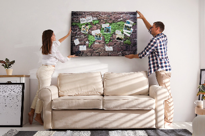 Prikbord met een wereldkaart in groentinten op een stenen muur