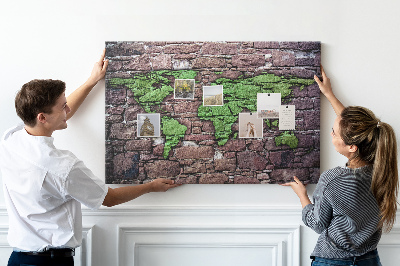 Prikbord met een wereldkaart in groentinten op een stenen muur