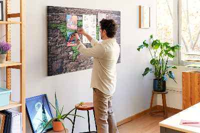 Prikbord met een wereldkaart in groentinten op een stenen muur