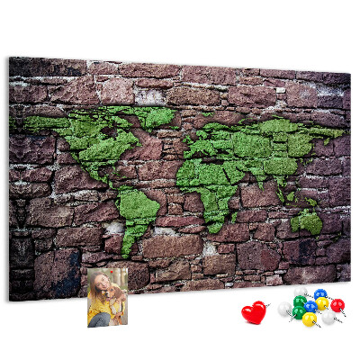 Prikbord met een wereldkaart in groentinten op een stenen muur