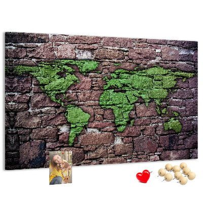 Prikbord met een wereldkaart in groentinten op een stenen muur