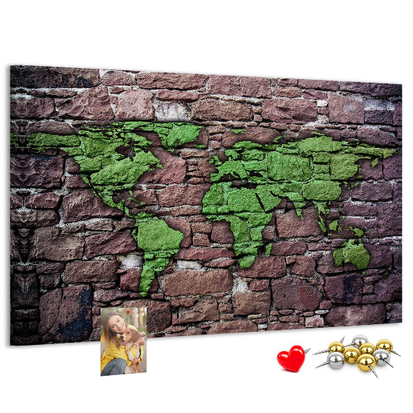 Prikbord met een wereldkaart in groentinten op een stenen muur