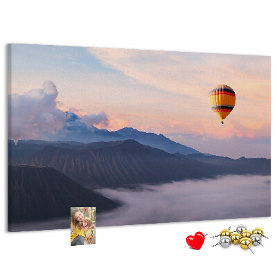 Prikbord met een ballon tegen een berglandschap bij zonsopgang