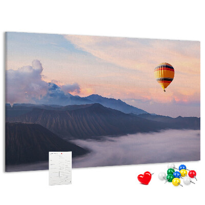 Prikbord met een ballon tegen een berglandschap bij zonsopgang