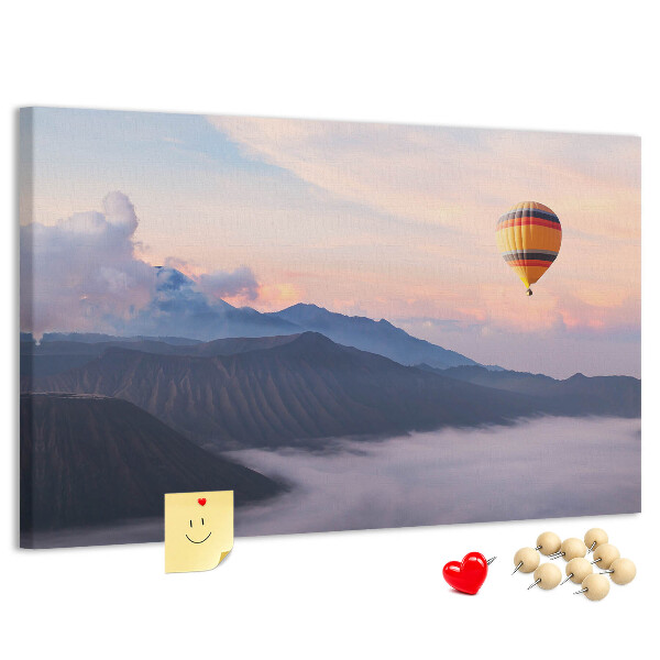 Prikbord met een ballon tegen een berglandschap bij zonsopgang