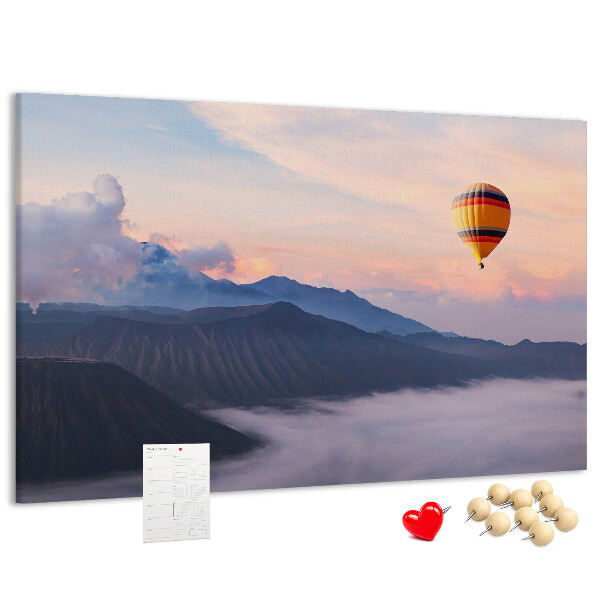 Prikbord met een ballon tegen een berglandschap bij zonsopgang