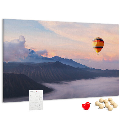 Prikbord met een ballon tegen een berglandschap bij zonsopgang