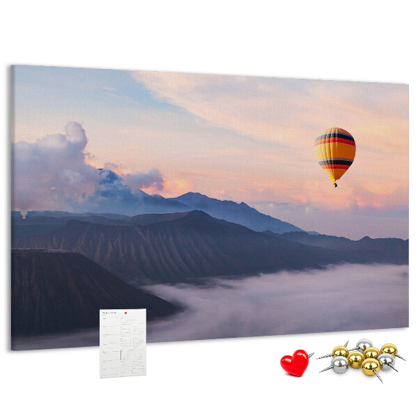 Prikbord met een ballon tegen een berglandschap bij zonsopgang