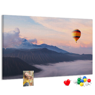 Prikbord met een ballon tegen een berglandschap bij zonsopgang
