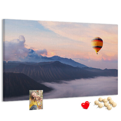 Prikbord met een ballon tegen een berglandschap bij zonsopgang