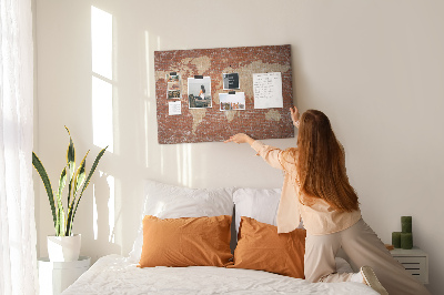 Kurkbord wereldkaart tegen een bakstenen muur
