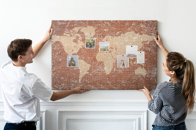 Kurkbord wereldkaart tegen een bakstenen muur