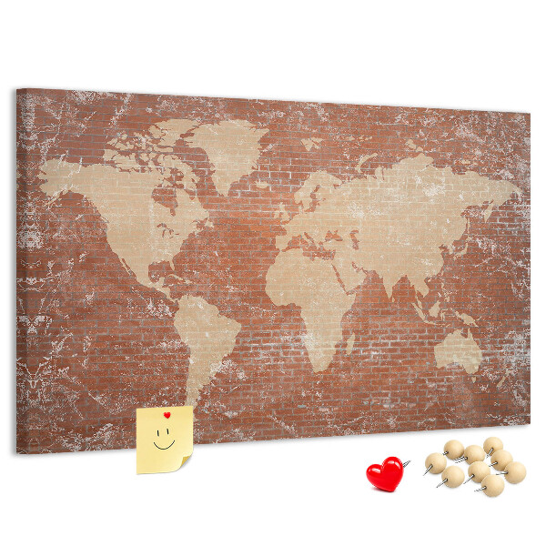 Kurkbord wereldkaart tegen een bakstenen muur