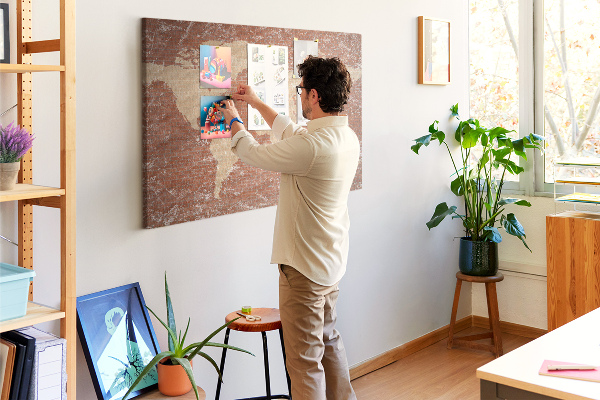 Kurkbord wereldkaart tegen een bakstenen muur