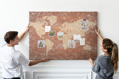 Kurkbord wereldkaart tegen een bakstenen muur