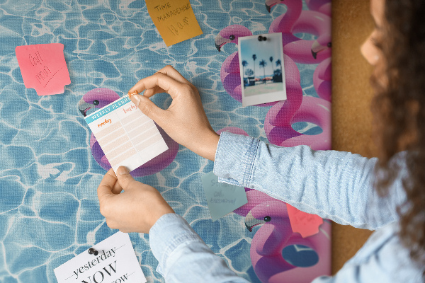 Prikbord met afbeelding van roze flamingo's tegen blauw water