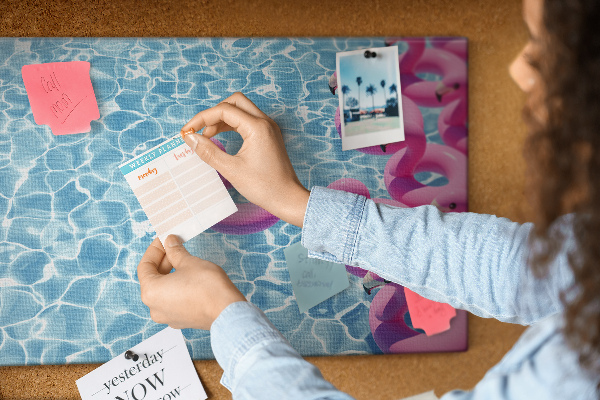 Prikbord met afbeelding van roze flamingo's tegen blauw water