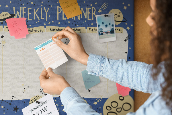 Kurkbord kosmische weekplanner met planeten en sterren