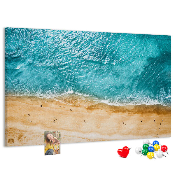 Kurkbord met een afbeelding van een strand met golven en voetsporen