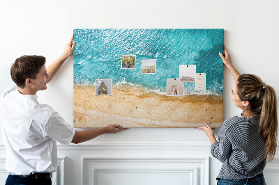 Kurkbord met een afbeelding van een strand met golven en voetsporen