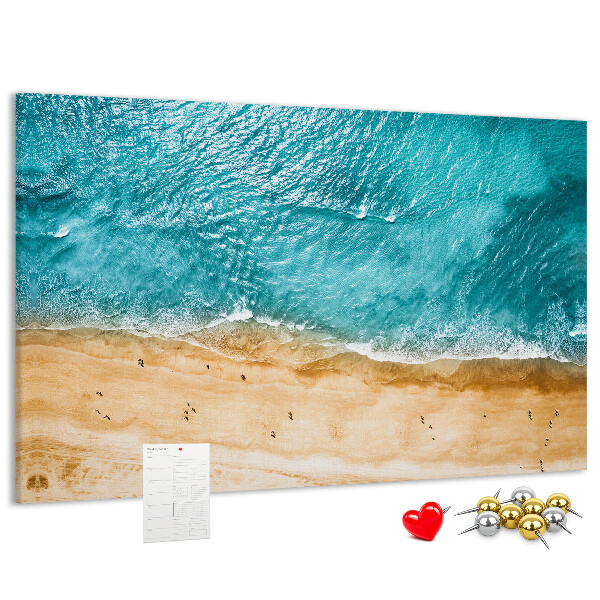 Kurkbord met een afbeelding van een strand met golven en voetsporen