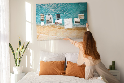 Kurkbord met een afbeelding van een strand met golven en voetsporen