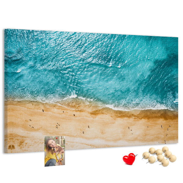 Kurkbord met een afbeelding van een strand met golven en voetsporen