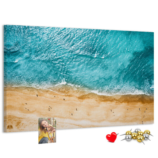 Kurkbord met een afbeelding van een strand met golven en voetsporen