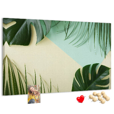 Kurkbord met tropische bladeren op een pastelkleurige achtergrond