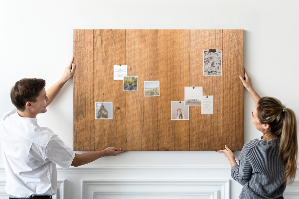 Prikbord van hout met gekleurde pinnen