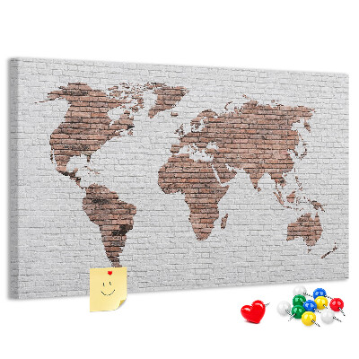Kurkbord wereldkaart met een achtergrond van een bakstenen muur