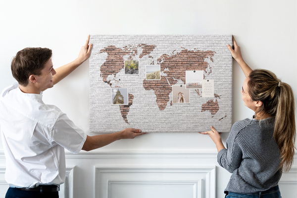 Kurkbord wereldkaart met een achtergrond van een bakstenen muur