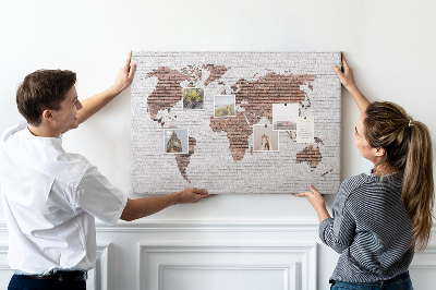 Kurkbord wereldkaart met een achtergrond van een bakstenen muur