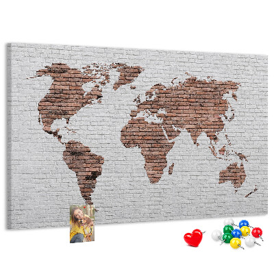 Kurkbord wereldkaart met een achtergrond van een bakstenen muur