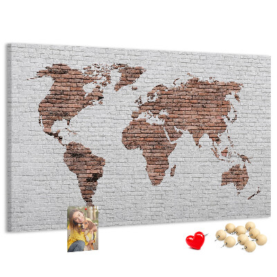 Kurkbord wereldkaart met een achtergrond van een bakstenen muur